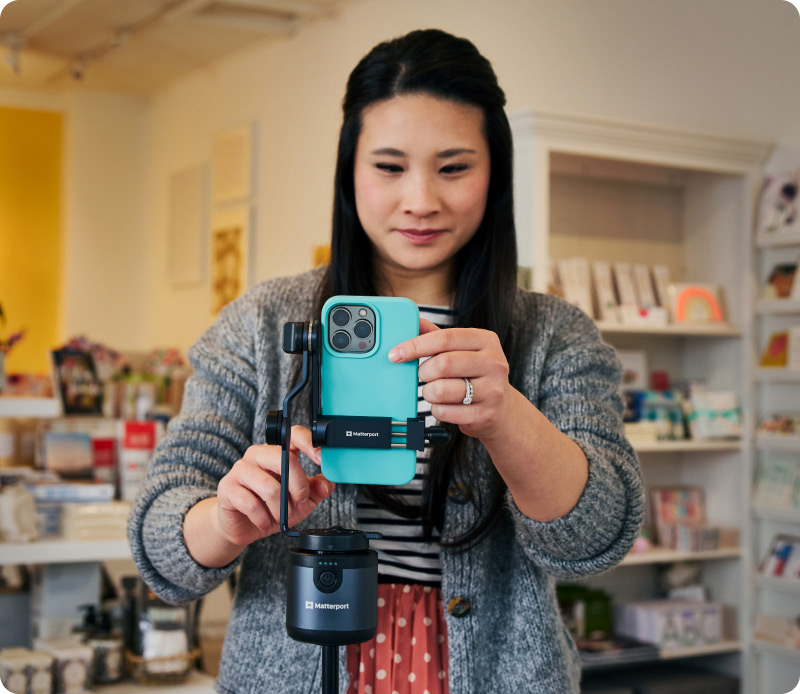 Woman using a blue iPhone with Matterport Axis