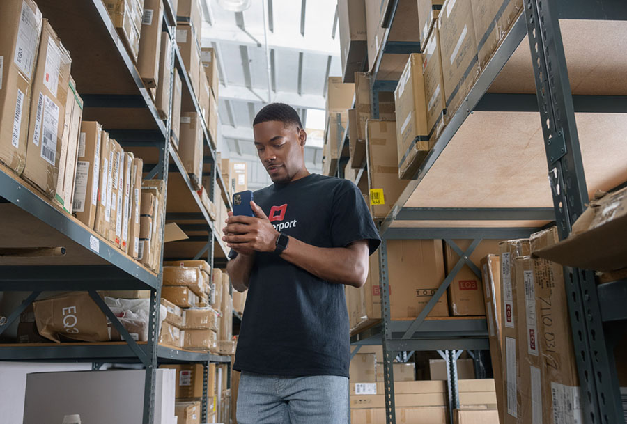 Man scanning warehouse with cell phone